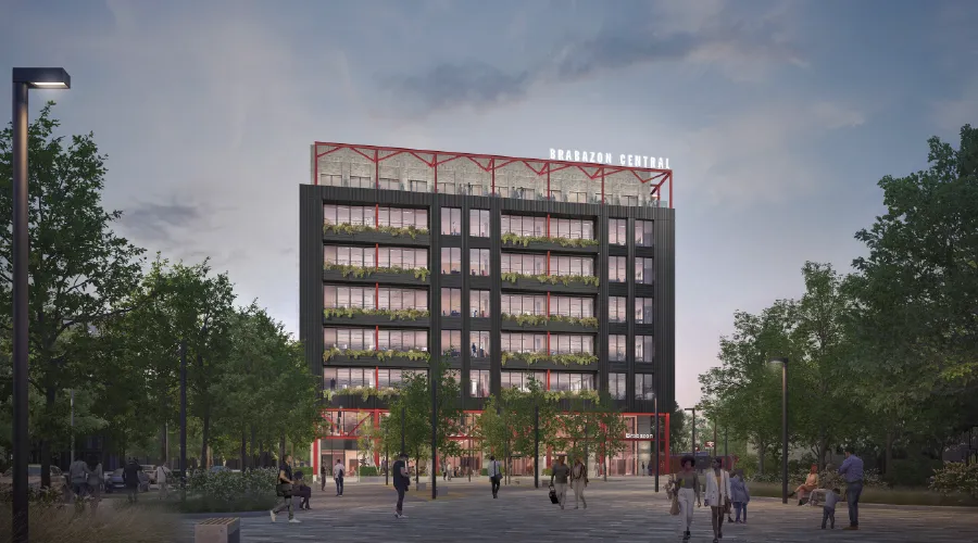 CGI of eight-storey office development from the station square at Brabazon, Bristol at dusk.