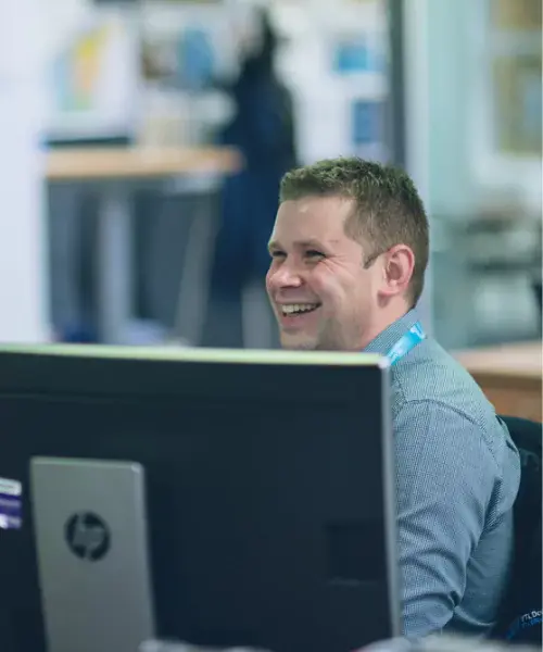 YTL Developments employee smiling behind a computer screen