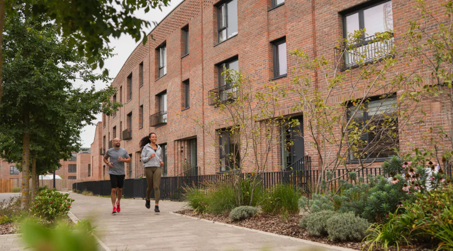 Residents running along a crescent of new-build townhouses at Brabazon, Bristol.